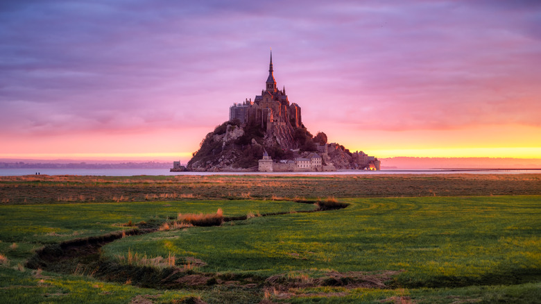 view from a field of the island mont sait-michel at sunset