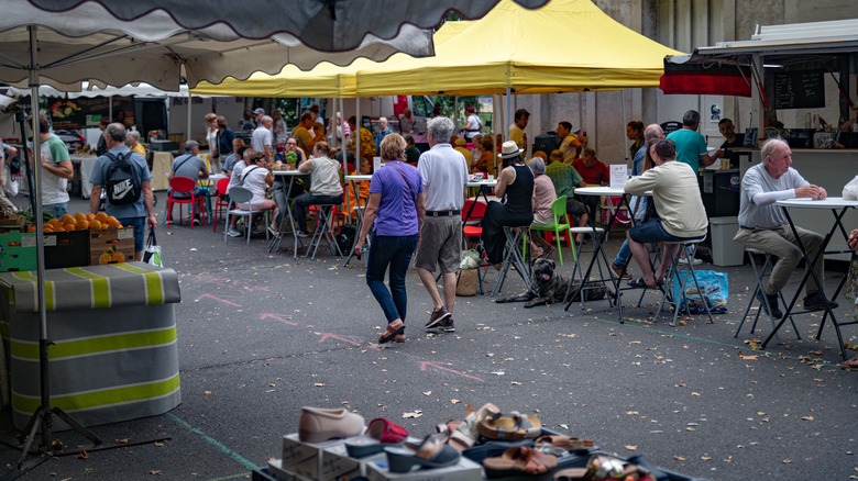 Tourists walking between vendors at the Amboise Market