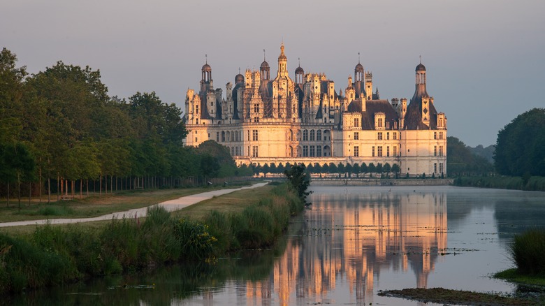 View of the Château of Chambord along the river at sunset