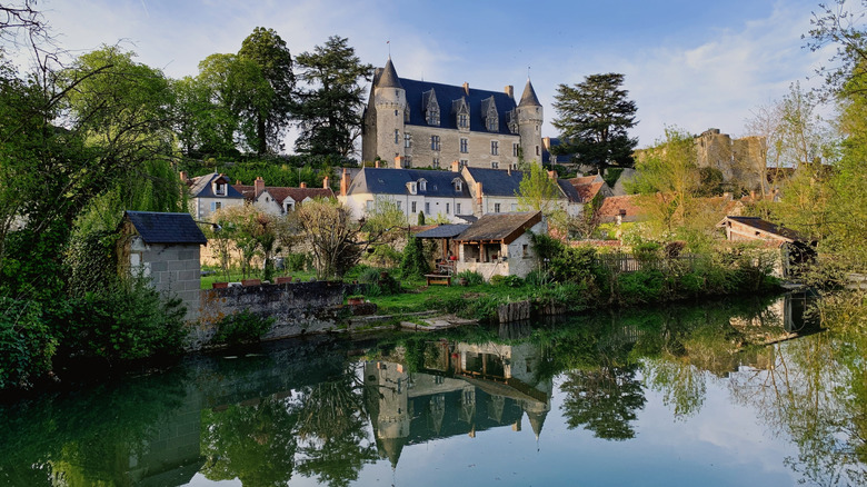 Château de Montrésor nestled on a hill behind a line of riverside village homes
