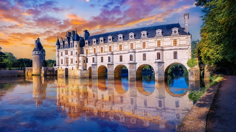 castle spanning the length of a river with seven arches at sunset