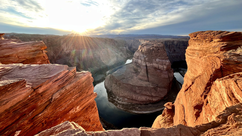 Horseshoe Bend with the sun setting behind the canyons of Grand Canyon National Park