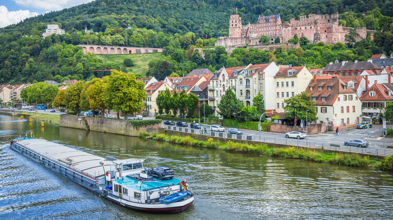 A river barge cruises by Heidelberg, with the castle in background