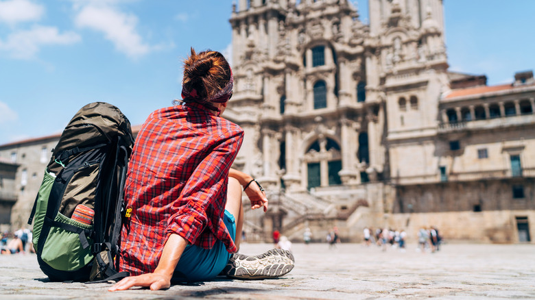Tourist sitting on the ground looking at building