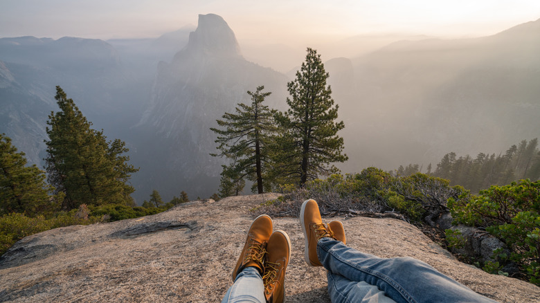 Personal perspective of couple relaxing on top of Yosemite valley in Yosemite National Park, California