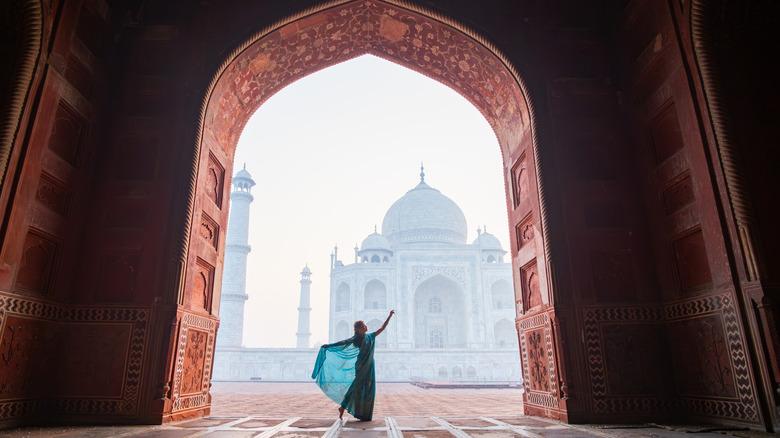 A woman dancing in front of the Taj Mahal in India
