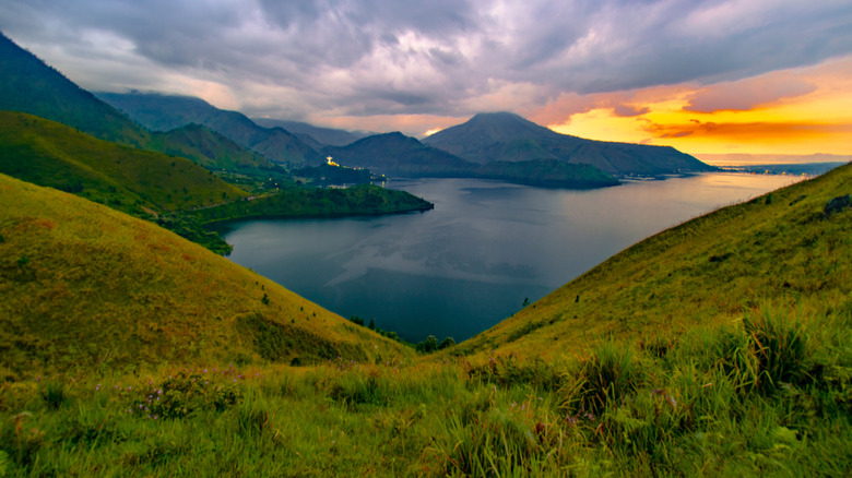 View of Indonesia's Lake Toba from a hill with dark cloud at sunset