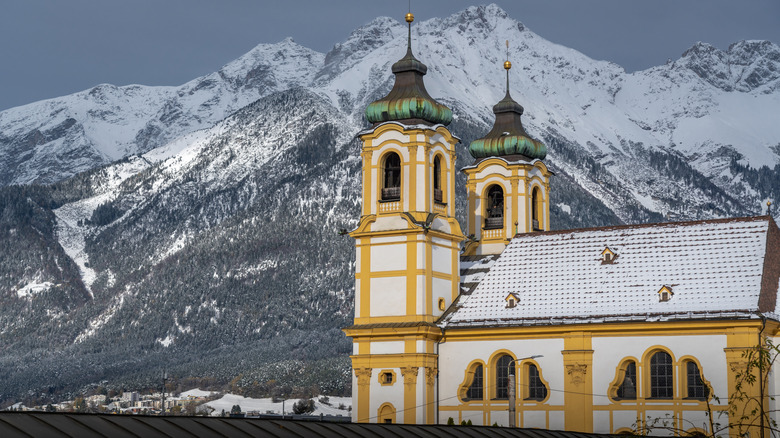 Wilten Basilica in front of snowy mountains in Innsbruck