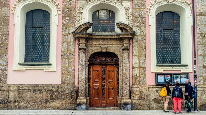 Tourists stand outside of a pink building in Old Town Innsbruck