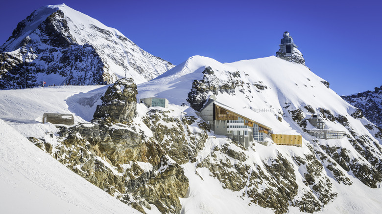 Buildings in a snowy mountain top peak on a sunny day