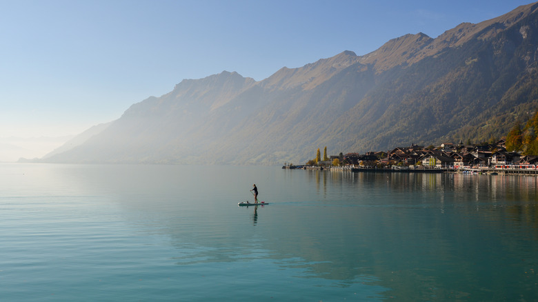 Paddleboarder on Lake Brienz with town and mountains in background