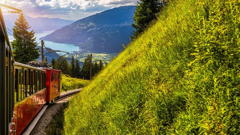 view of mountain and lake in the distance from cogwheel train winding around a curve