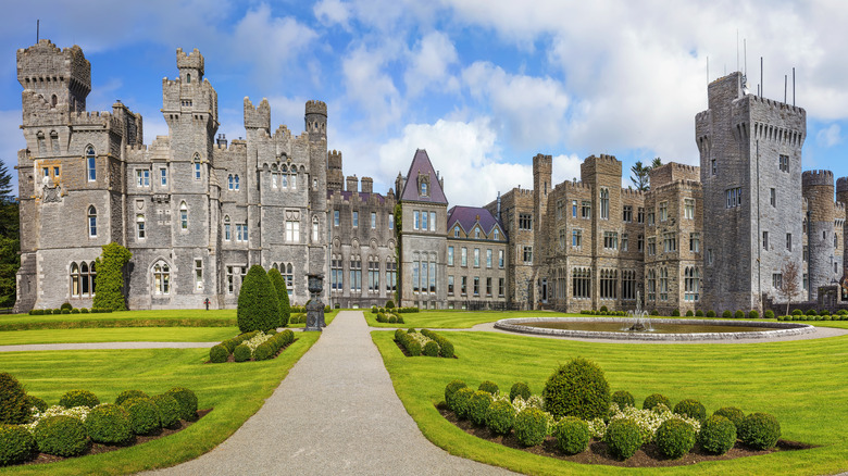 View of the intricate stone facade and front drive at Ashford Castle, a five-star hotel in County Mayo, Ireland