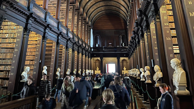 View of the wood-paneled Long Room library lined with marble busts at Trinity College, Dublin, Ireland