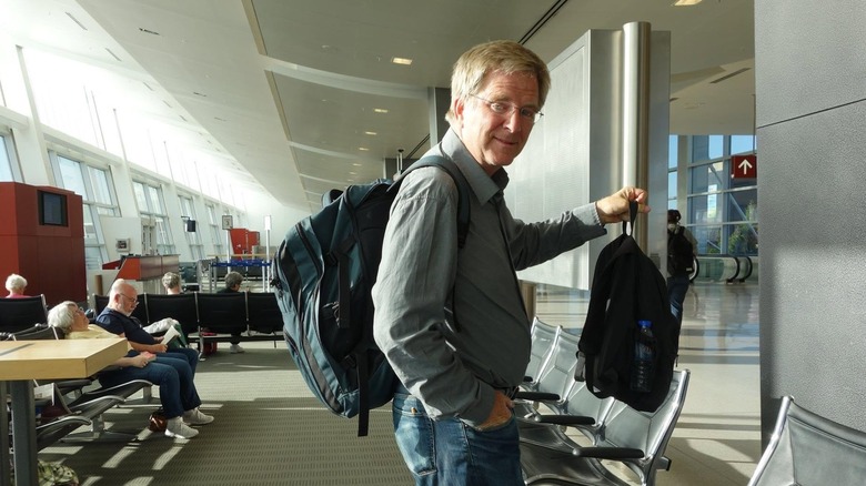 Rick Steves traveling through an airport
