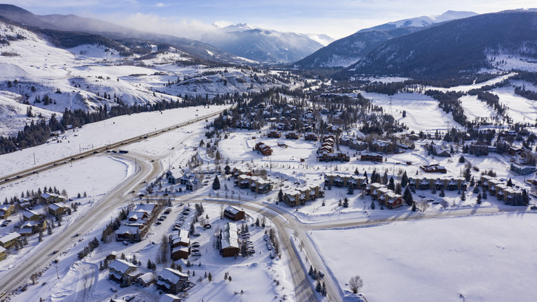 Aerial view of Keystone, Colorado snow-covered homes and resorts surrounded by mountains.