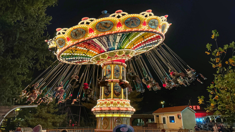 People on an illuminated carousel ride at night at Knoebels Amusement Resort.
