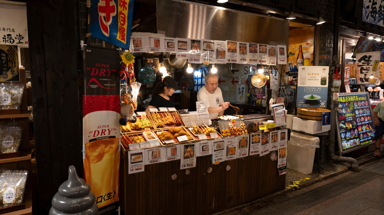 View of food stalls in Kyoto's Nishiki Market, where locals and travelers can buy a wide variety of Japanese foods