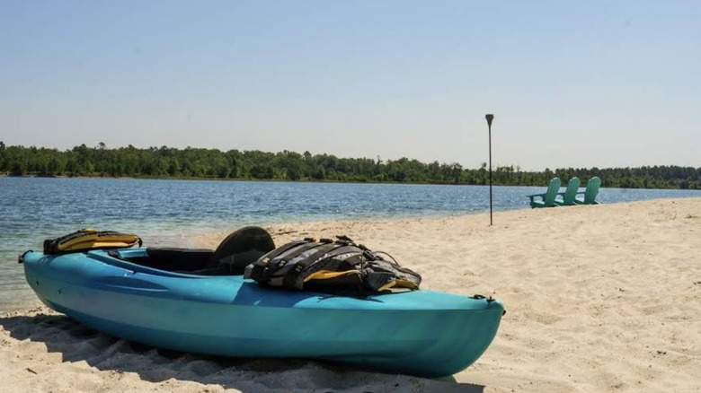 A kayak and life preserver on the sandy shore of Lake Isabel Farm in Louisiana