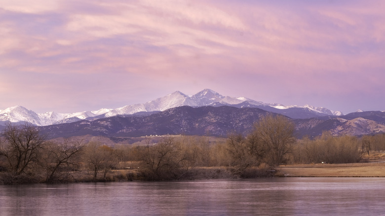 A snowcapped mountain with pink sky