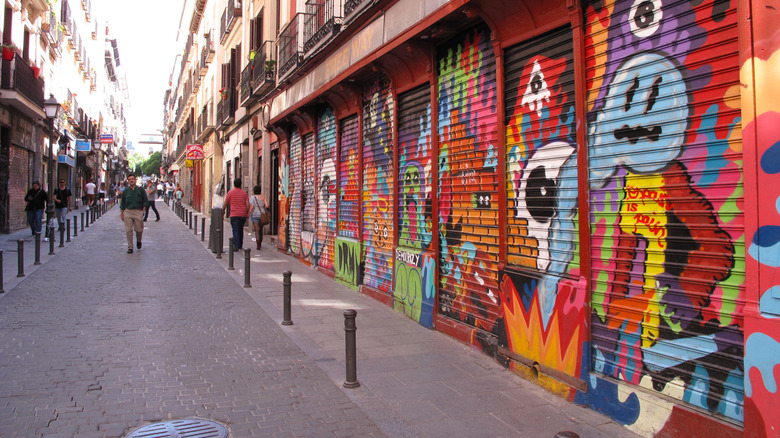a pedestrian street in Malasaña lined with murals and graffiti