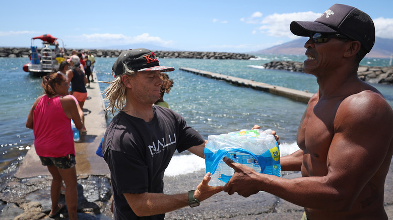 Volunteers load water onto a boat to be transported to Lahaina