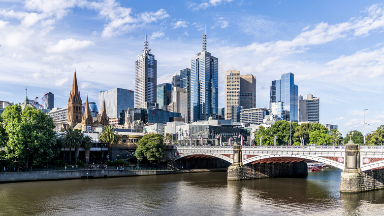 View of the Melbourne Skyline in the background with a historic bridge and the Yarra River in the foreground