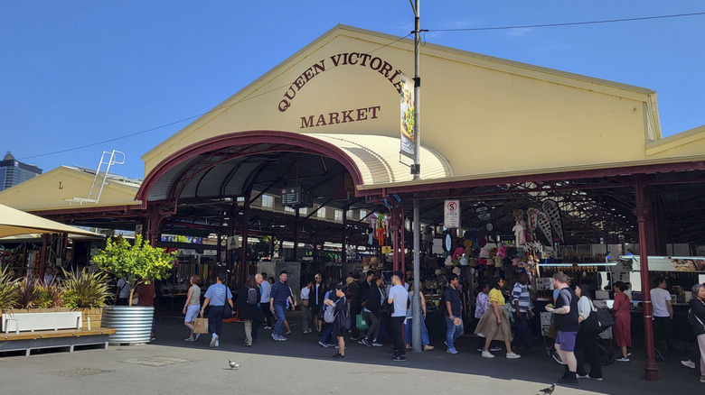 People milling outside the entrance of the 900,000-square-foot Queen Victoria Market on a sunny day in Melbourne, Australia