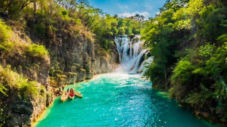 People swim in a pool at the base of a waterfall in Huasteca Potosina