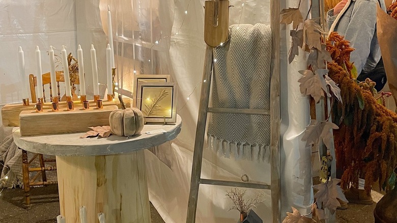 Photo of vendor booth candles and scarves decorated for autumn.