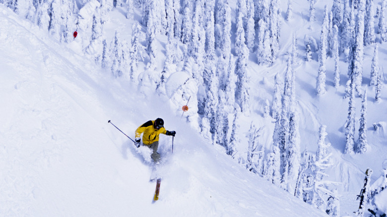 Skier making a big turn below a peak in Whitefish, Montana.
