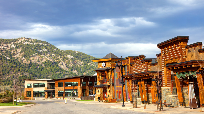 wooden lodgings with mountains in the background under cloudy sky