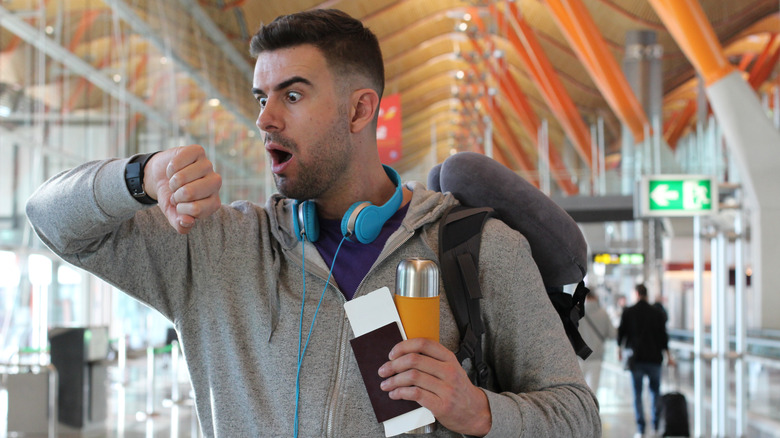 A man at an airport with a sense of panic on his face