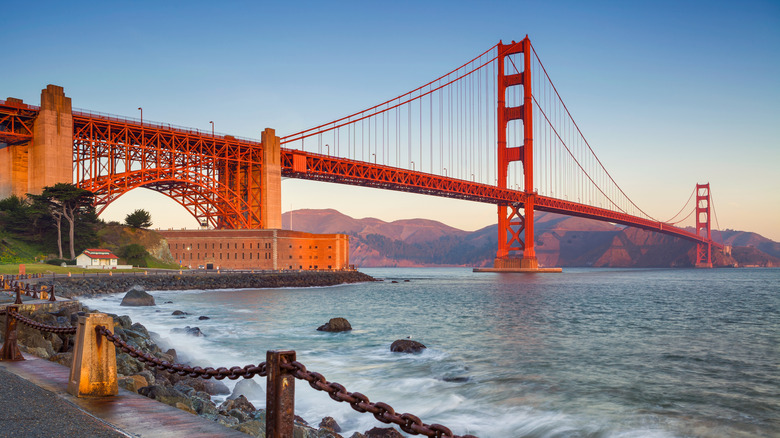 view of golden gate bridge at sunrise from a scenic trail below
