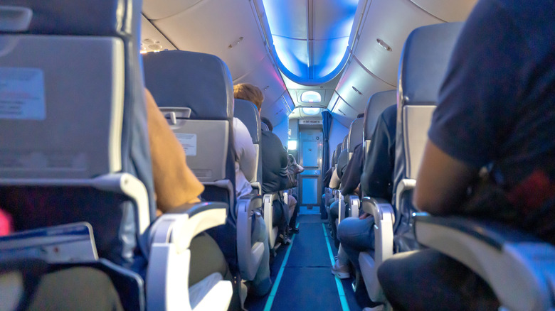 A view up the aisle of an airplane with passengers in their seats.