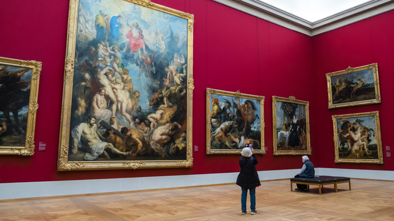 Museum visitors at Alte Pinkothek look up at huge oil paintings