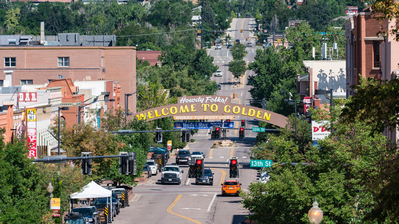 A scene of downtown Golden, Colorado and city's "Welcome to Golden" arch on a sunny day