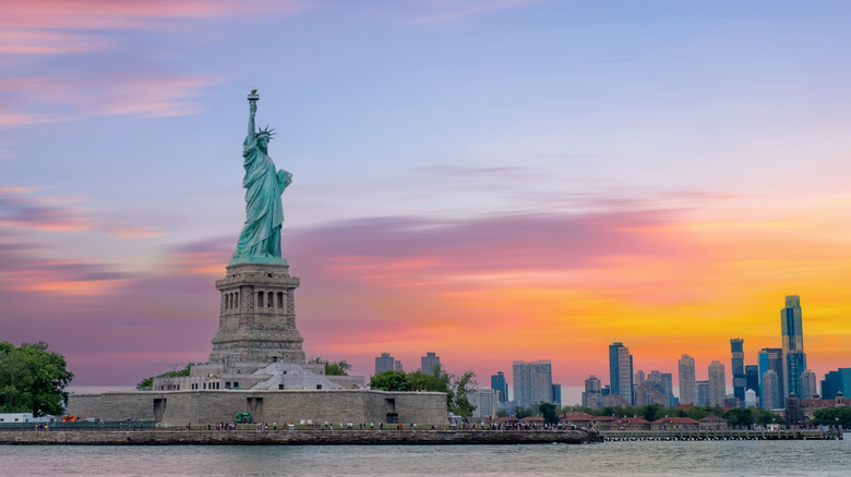 The Statue of Liberty and Liberty Island at sunset in New York Harbor