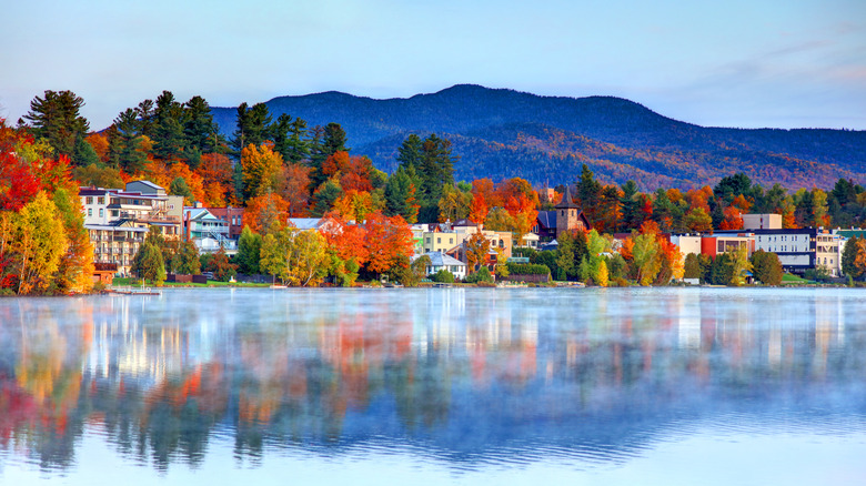 A mountain, trees in autumn colors, and houses near Lake Placid