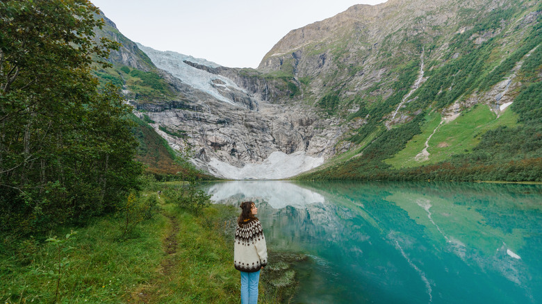 Woman in knitted sweater gazes up at Norway's Jostedal Glacier