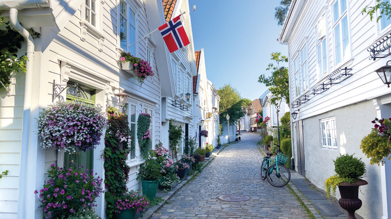 White houses, flowers, and a Norwegian flag on the cobbled streets of Gamle Stavanger