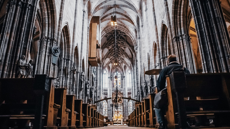 Visitor sitting on a pew in St. Lawrence Church, Nuremberg