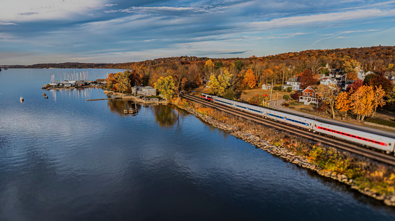 An Amtrak train travels along the Hudson River in Hudson, New York