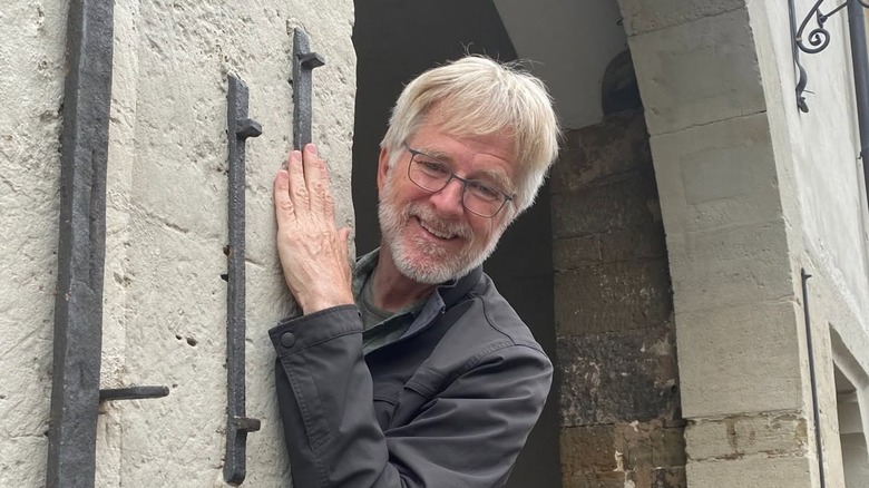 Rick Steves posing in the entryway of an ancient building