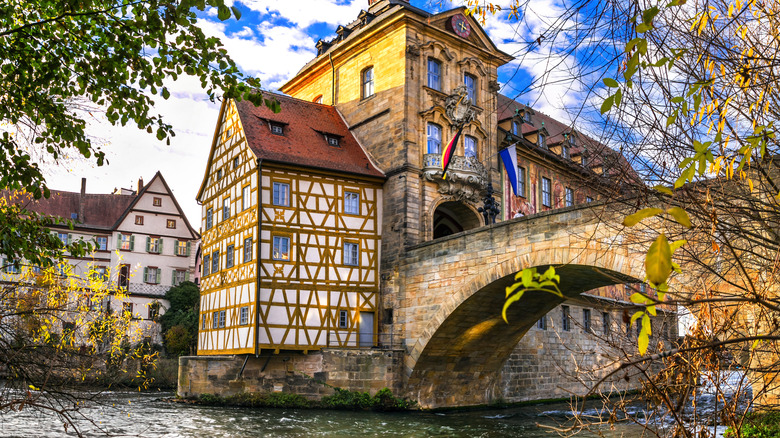 Half-timbered building connected to a bridge over a river in Bamberg, Germany, during the early fall