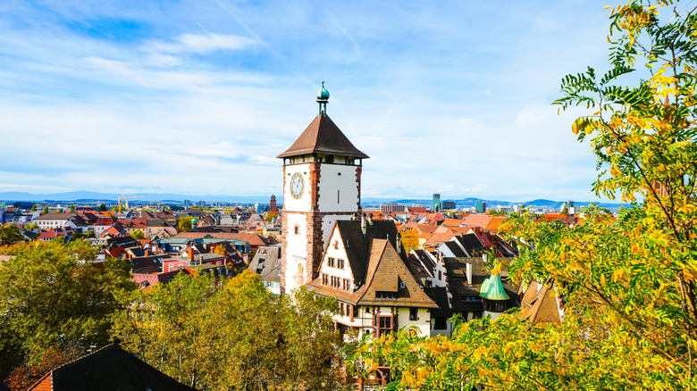 Aerial view of Freiburg, Germany, with a tall steeple surrounded by the Black Forest