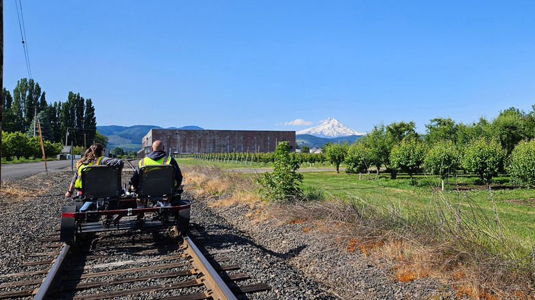 People riding a railbike in Hood River with the towering Mount Hood in the background