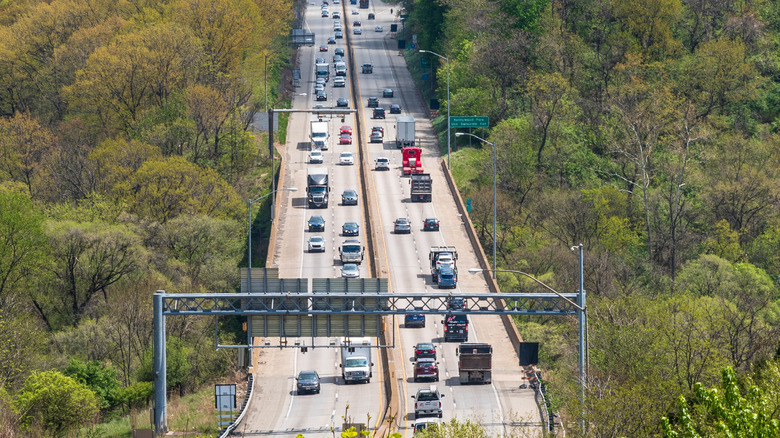 Wide angle view of busy highway in Pennsylvania surrounded by green trees.