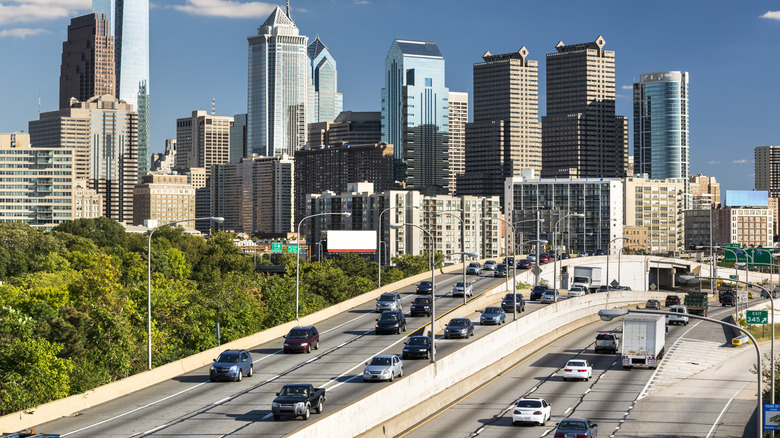Philadelphia skyline in background with a busy highway in the foreground.
