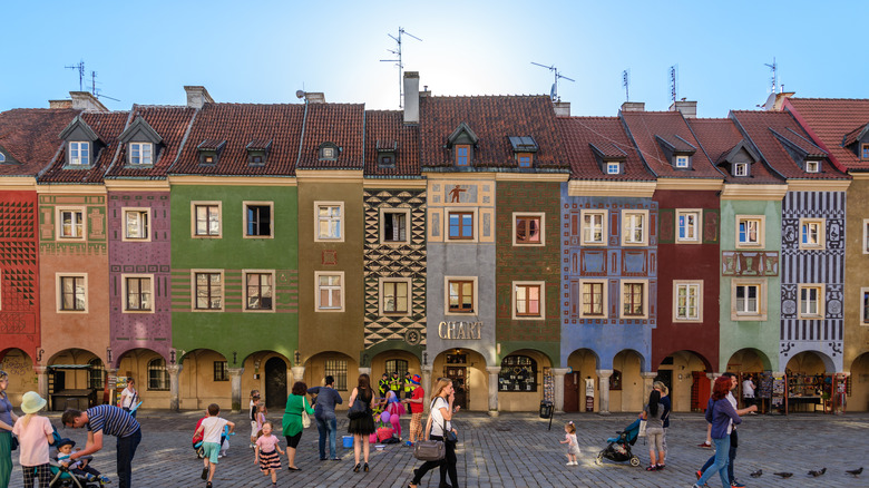 The unique colorful facades of Poznań Market Square in Poland on a crowded summer evening